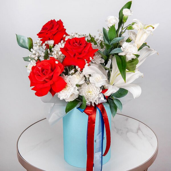 Red rose Nina 50 cm - 7, Gypsophila - 1, Baltica White Spray Chrysanthemum - 1, White spray carnation - 4, Carnation white, cream - 3, Lilies - 1, Round flower box medium, Oasis, Ruscus, Ribbon