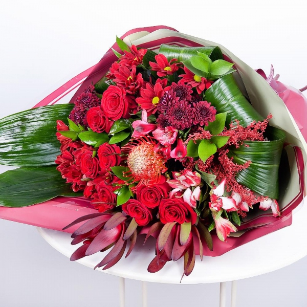 Bacardi Red Spray Chrysanthemum - 4, Red rose 50 cm - 12, Alstromeria Red, Bright Pink - 5, Daisy poms Santini pink, purple - 3, Leukodendron, Aspidistra (1 pc.), Solidago (1 pc.), Wrapping Paper, Ribbon, Ruscus, Nutan