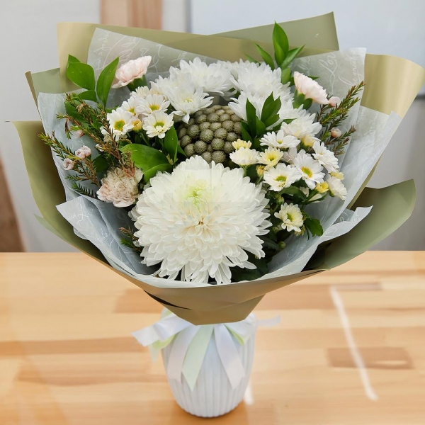 Magnum White Chrysanthemum - 1, Baltica White Spray Chrysanthemum - 3, Carnation white, cream - 7, Santini White Spray Chrysanthemum - 2, Brunia Green Lanuginosa (1 pc.), Waxflower (1 pc.), Ruscus, Wrapping Paper, Ribbon